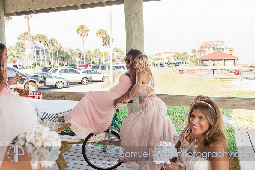 Bridesmaids riding bike beach wedding