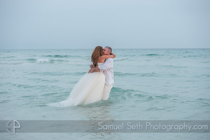 bride and groom in water on beach