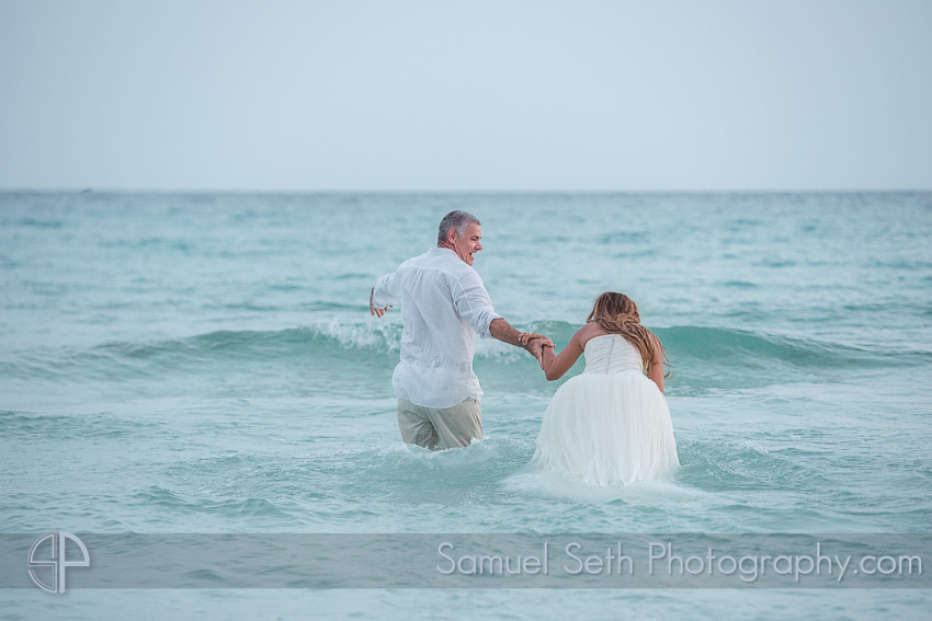 Bride and Groom running into ocean